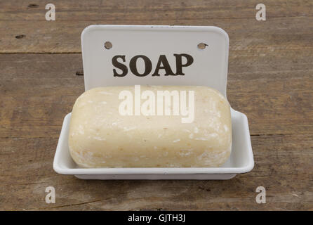 Bar of soap in vintage soap dish on rustic wood Stock Photo