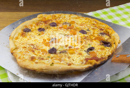 Olive and anchovy pizza on metal pizza spade Stock Photo