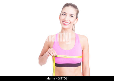 Girl at gym measuring her bust with tape line and smiling isolated on white background Stock Photo