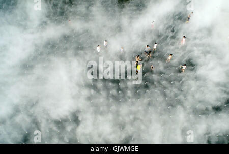 Quanzhou, China's Fujian Province. 16th Aug, 2016. People enjoy coolness among vapour on a square at the Maritime Silk Road Art Park in Quanzhou City, southeast China's Fujian Province, Aug. 16, 2016. Credit:  Zhang Jiuqiang/Xinhua/Alamy Live News Stock Photo