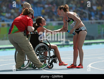 Rio De Janeiro, RJ, Brazil. 17th Aug, 2016. New Zealand's Nikki Hamblin reaches out a hand of thanks to USA's Abbey D'agostino (in chair) after the two tangled and fell during the 5,000 race heats and despite a torn ACL D'agostino stayed back to help Hamblin up. A pure sign of sportsmanship in a sea of competition. ] 2016 Summer Olympic Games - Rio Brazil.brian.peterson@startribune.com.Rio de Janeiro, Brazil - 08/17/2016. Credit:  Brian Peterson/Star Tribune/ZUMA Wire/Alamy Live News Stock Photo