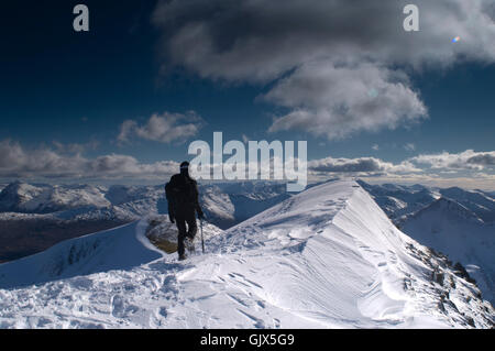 Mountaineer in winter snow on a ridge in the Mamore mountain range near Glencoe and Ben Nevis inthe Scottish Highlands Stock Photo