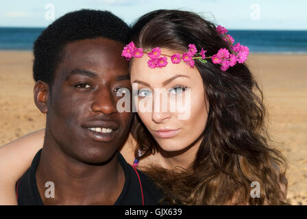Young couple multicultural head shot heads together looking serious on beach  romantic hipster emotions Stock Photo