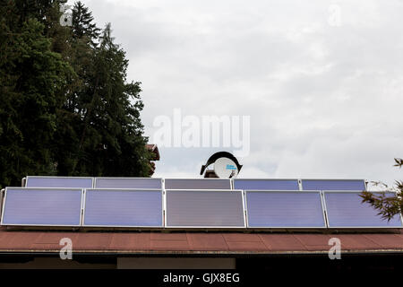 Roof house with solar panels and dish satellite Stock Photo