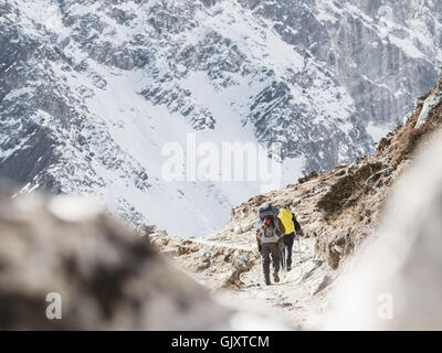 Hikers carefully follow the trail near Lobuche, Nepal on their Everest Base Camp journey through the Himalayas Stock Photo