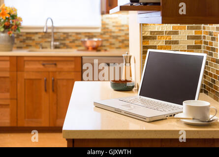 Laptop computer wireless wifi technology in contemporary upscale home kitchen interior. Working from home office. Stock Photo