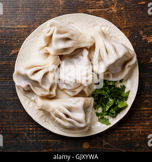 Georgian dumplings Khinkali with meat and greens coriander leaves on white plate Stock Photo
