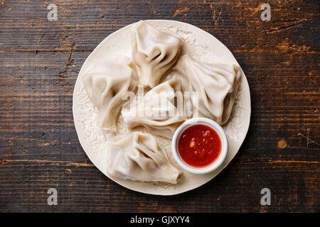 Georgian dumplings Khinkali with meat and tomato spicy sauce Satsebeli on white plate Stock Photo