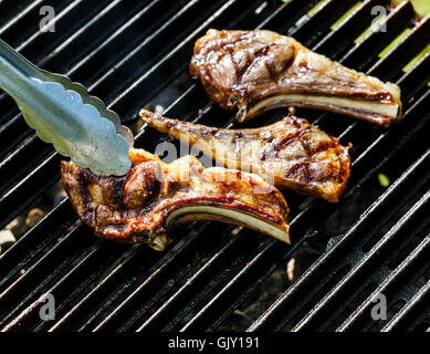 Grilled lamb ribs on cast iron grill BBQ background Stock Photo