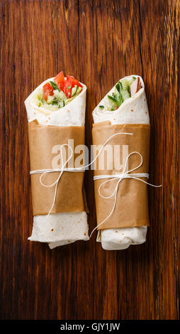 Tortilla wraps sandwiches with fresh vegetables on wooden background Stock Photo