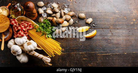 Dark wooden background with Ingredients for cooking Spaghetti vongole Stock Photo