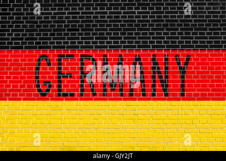 Flag of Germany on brick wall texture background. German national flag. Word Germany. Stock Photo