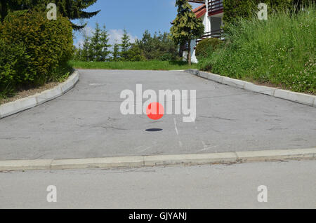 Blank, red, round, metal plate hanging on a stretched wire to stop entry to a private property. Stock Photo