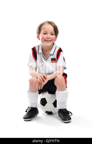 boy sitting on a football Stock Photo