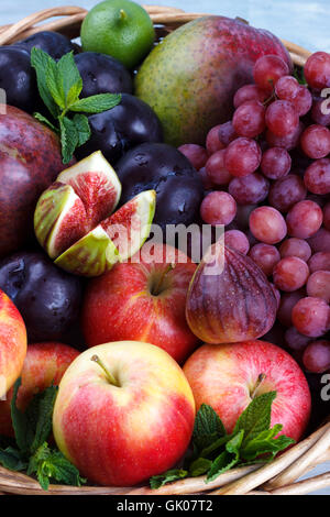 Basket of fresh organic fruits in the garden on rustic background Stock Photo