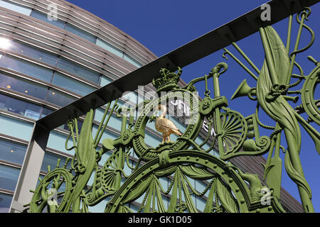 A gold coloured Liver bird on the gate to the former Sailor's Home in Liverpool. John Lewis store in background. Stock Photo
