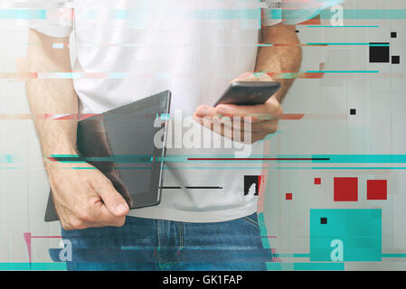 Guy using smartphone and digital tablet computer, modern mobile electronic devices, to access internet and social networks. Stock Photo