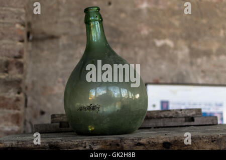 Old green dusty bottle on a shelf in the Italian countryside Stock Photo