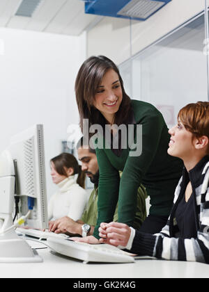 Hispanic teacher helping students with computers Stock Photo - Alamy