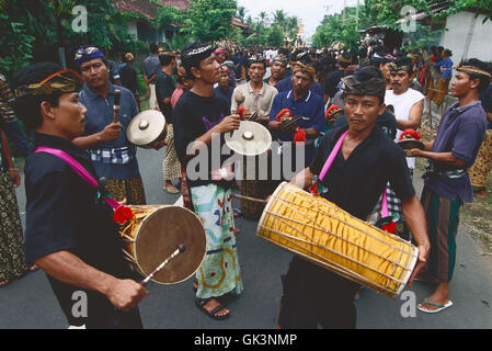 ca. 2000, Ubud, Gianyar Regency, Bali, Indonesia --- A group of men play drums and cymbals as part of a funeral procession in Ub Stock Photo