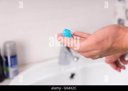 Shaving gel on man's hand in front of  washbasin in the modern tiled bathroom at home Stock Photo