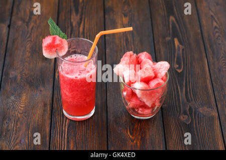 Glasses of watermelon smoothie and heartshapes on wooden background Stock Photo