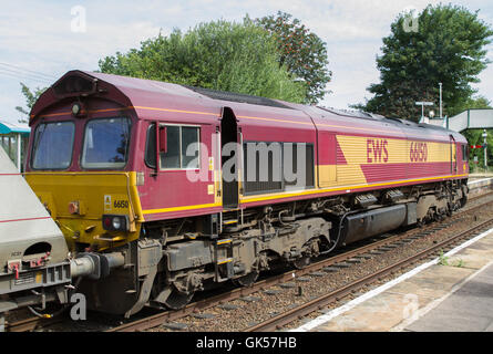 DB Cargo Class 66 Diesel locomotive working a train of empty hopper wagons (used for carrying sand) at Helsby station, Cheshire Stock Photo