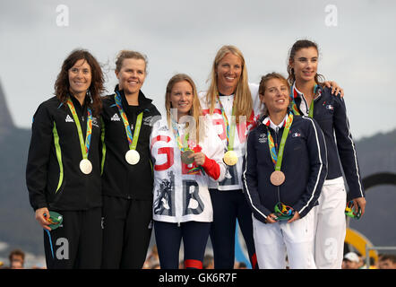 Great Britain's Hannah Mills (centre left) and Saskia Clark (centre right) with celebrate on the podium with their gold medals alongside silver medallists, New Zealand's Jo Aleh and Polly Powrie and bronze medalists France's Camille Lecointre and Helene Defrance from the Women's 470 Race at Marina da Gloria on the thirteenth day of the Rio Olympic Games, Brazil. Stock Photo