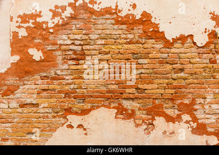Texture of an old brick wall with weathered plaster in Italy Europe Stock Photo