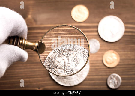 Examining antique silver coin Stock Photo