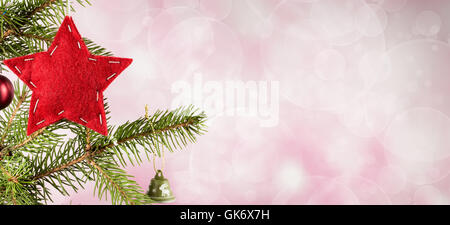 Felt red star from left side of pink bokeh background Stock Photo