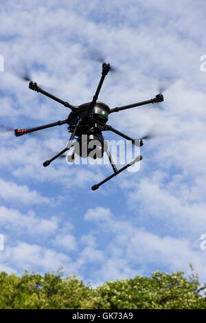 Yuneec Typhoon 920 hexacopter drone with gimbal mounted camera in flight against a cloudy blue sky Stock Photo