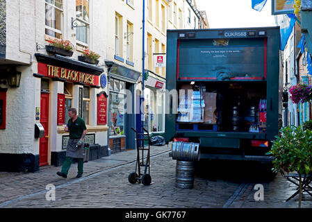 Carlsberg lorry parked on cobbled street outside pub, the Black Horse, Whitby, North Yorkshire, England UK Stock Photo