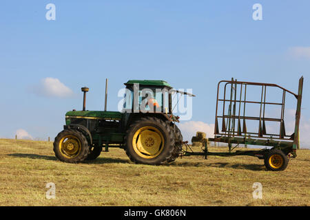 Littleborough, UK. 18th August, 2016. UK Weather: A farming family work into the evening to make hay while the sun shines. Pictured: A John Deere 3050 Tractor been used during hay making on farm land in Littleborough, 18th August, 2016 Credit:  Barbara Cook/Alamy Live News Stock Photo