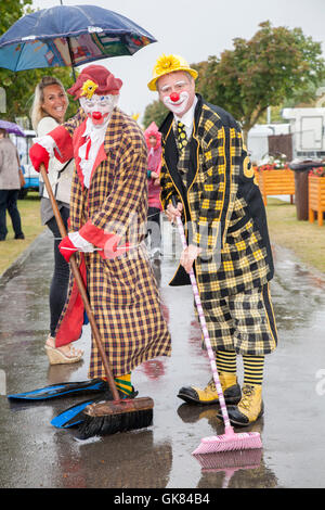 Southport Flower Show, Merseyside, UK. 19th Aug 2016:  Red-nosed Sunny the Clown, (Sonny and Rainbow).  Heavy rains couldn't dampen the spirits of the visitors to this year's Southport Flower Show.  Umbrellas and wellies were the top fashion tip of the day. The largest independent flower show in England, is expecting thousands of visitors over the four day event.  Show Chairman and Trustee David Rose has employed road sweepers & clowns to keep the paths clear of any puddles so the elegant ladies can keep their feet dry. Credit:  MediaWorld Images/Alamy Live News Stock Photo