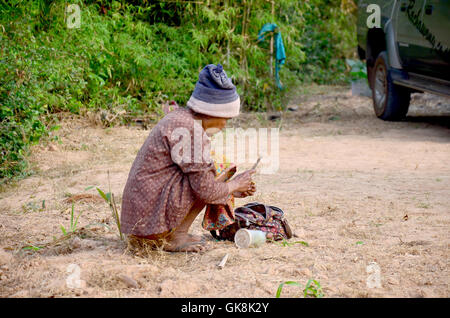 Old woman thai people use knife preparing betel vine for eat in morning time at Ban Non Hom on January 17, 2016 in Sakon Nakhon, Stock Photo