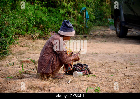 Old woman thai people use knife preparing betel vine for eat in morning time at Ban Non Hom on January 17, 2016 in Sakon Nakhon, Stock Photo