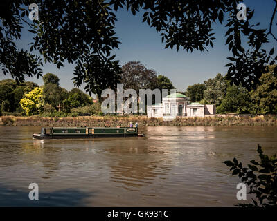 Canal barge sailing past Syon Park on the River Thames Iselworth London UK Stock Photo