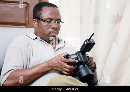 African photographer looking at the screen of his digital camera. Stock Photo