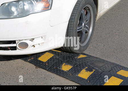 car tire encounters a sleeping policeman Stock Photo