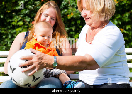 family - grandmother,mother and child in the garden Stock Photo