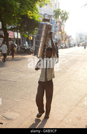 Indian man carrying steel food containers, Stock Photo