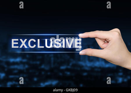 hand pushing exclusive button on blurred blue background Stock Photo