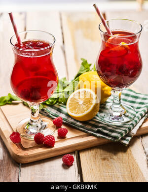On wooden boards two ice glasses with red raspberry cocktail Stock Photo