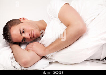 beautiful young man lying in bed Stock Photo