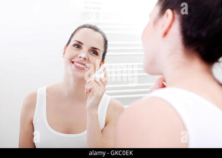 young brunette woman girl with cream in bathroom Stock Photo