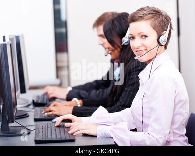 call center staff friendly with headphones on computer Stock Photo