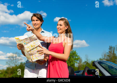 young couple with cabriolet in summer on a trip Stock Photo
