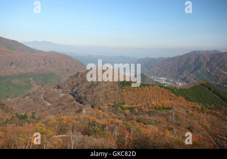 Red, orange, yellow and green leaf trees seen from the road at a viewpoint about 3000m above sea-level. Autumn season in Nikko Stock Photo