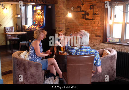 Friends enjoying a drink in the Cinque Ports Inn pub in New Romney Kent UK Stock Photo